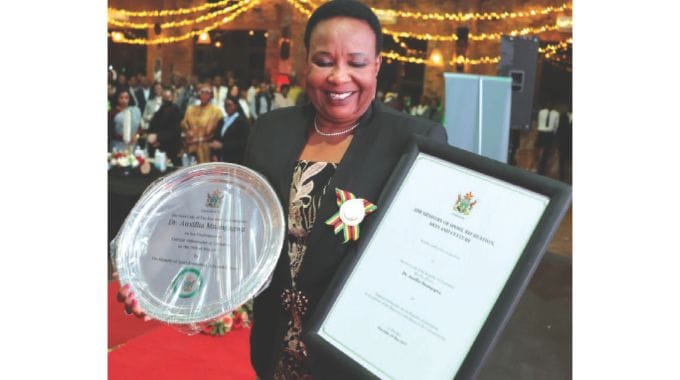 Zimbabwe’s Cultural Ambassador First Lady Dr Auxillia Mnangagwa displays her medal,award and certificate after she was conferred with the Culture Ambassador role at the Heritage Museum in Harare