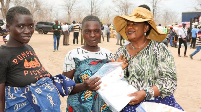 First Lady Dr Auxillia Mnangagwa shares a lighter moment with expecting mothers after presenting them with baby preparation kits at Chapoto Secondary School in Kanyemba
