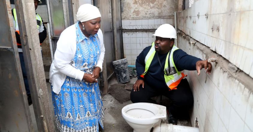 First Lady Dr Auxillia Mnangagwa listens as Tino Pande explains the progress of renovation works at Matapi Flats in Mbare.