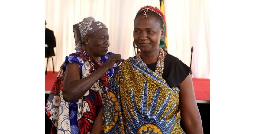 An elderly BaTonga woman demonstrates to a younger woman how to wrap a zambia in a cultural and traditional way