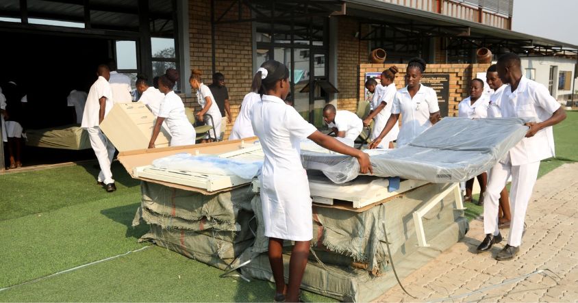 Dr Auxillia Mnangagwa School of Nursing student nurses carry beds and essential equipment donated by First Lady Dr Auxillia Mnangagwa to the institution in Kadoma